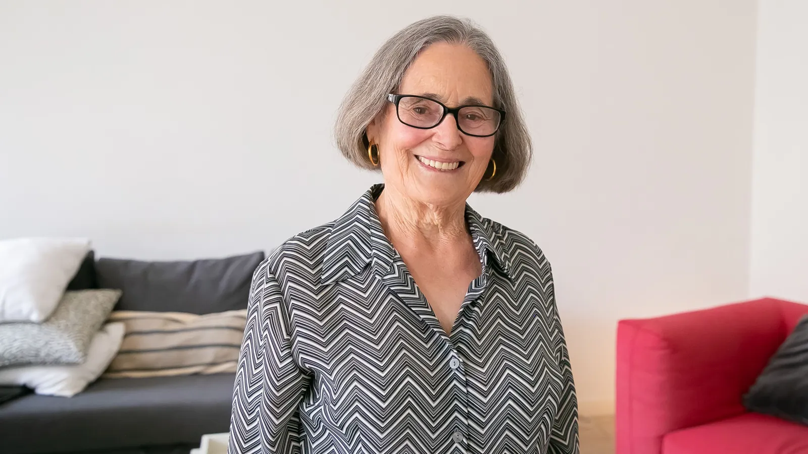 Femme âgée souriante, chez elle, dans son salon